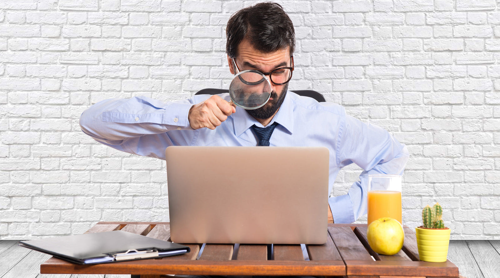Man in shirt and tie sitting behind computer thinking about the size of his penis