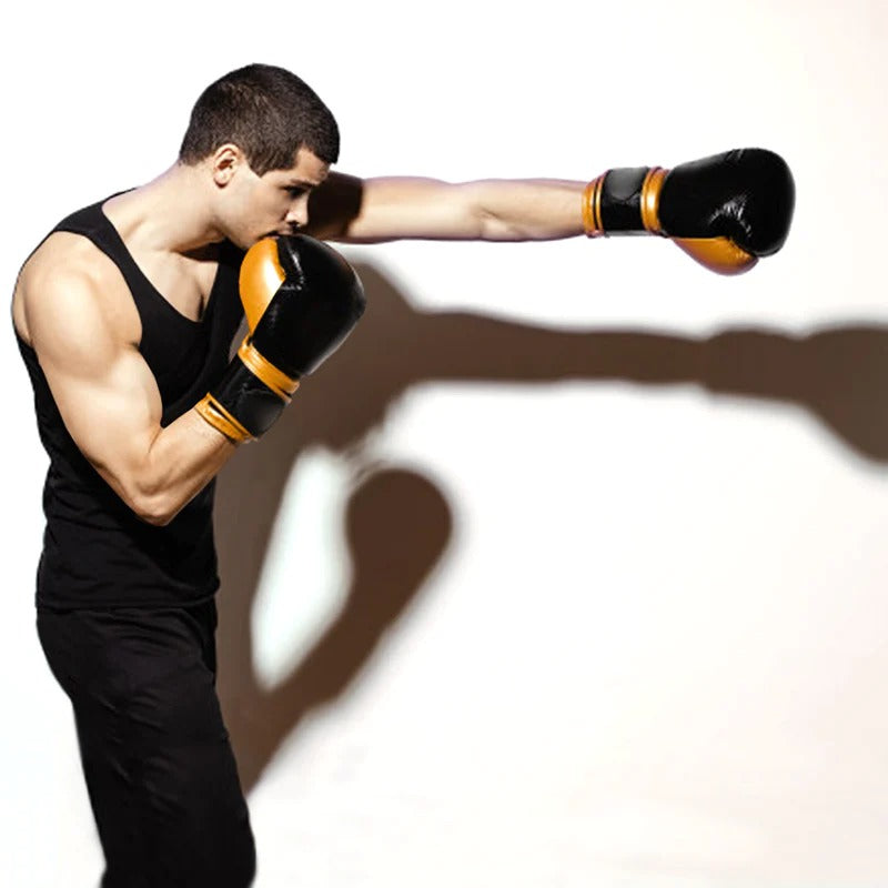 You man in black tank top, black jeans and boxing gloves throwing a punch